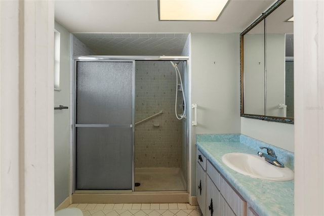 bathroom featuring tile patterned floors, vanity, and a shower with shower door