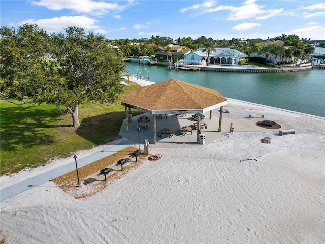 surrounding community with a gazebo, a water view, and a lawn