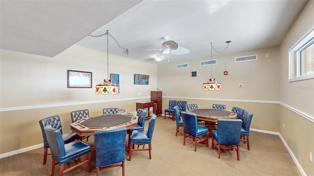 dining space featuring ceiling fan and light colored carpet