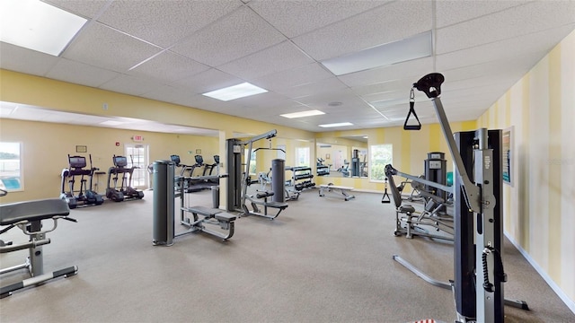 gym featuring a paneled ceiling and a wealth of natural light