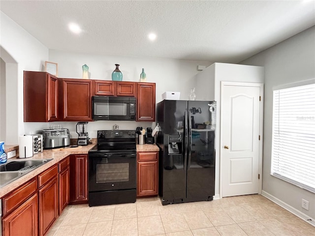 kitchen featuring black appliances, light tile patterned floors, sink, and a textured ceiling