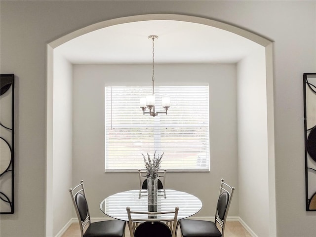 carpeted dining room with plenty of natural light and a chandelier