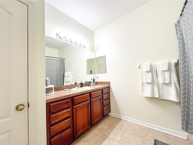 bathroom featuring tile patterned flooring, vanity, and a textured ceiling