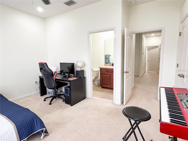 bedroom with ensuite bath and light colored carpet