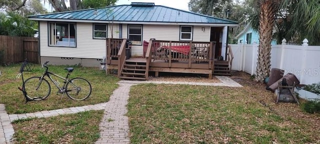 rear view of house featuring a deck and a yard