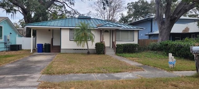 bungalow featuring a front yard and central AC unit