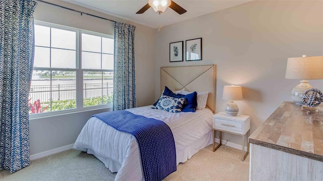 bedroom featuring light colored carpet, multiple windows, and ceiling fan