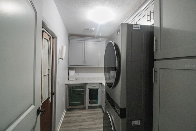 kitchen with hardwood / wood-style floors, a textured ceiling, and stainless steel refrigerator