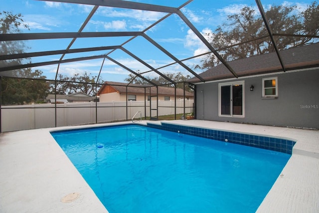 view of swimming pool with a patio and glass enclosure