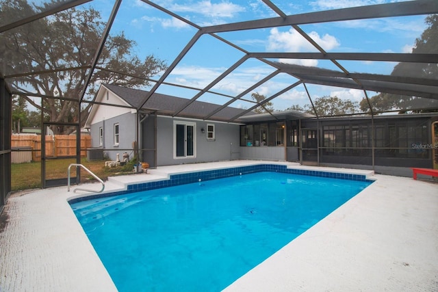 view of swimming pool with central AC, a sunroom, a lanai, and a patio area