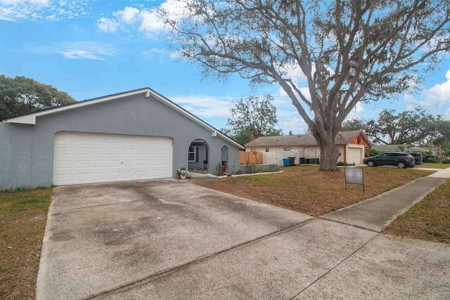 single story home with a garage and a front lawn