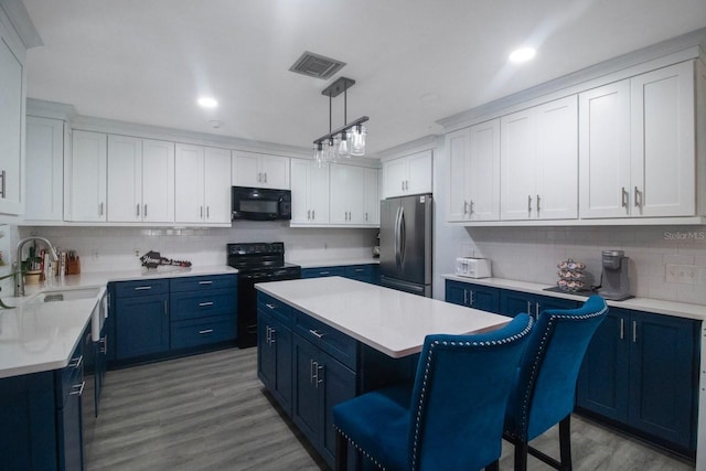 kitchen with pendant lighting, white cabinetry, black appliances, and a kitchen island