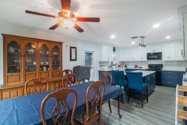 dining area with ceiling fan and light wood-type flooring