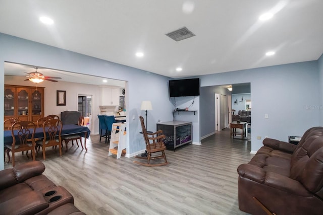 living room with ceiling fan and light hardwood / wood-style flooring