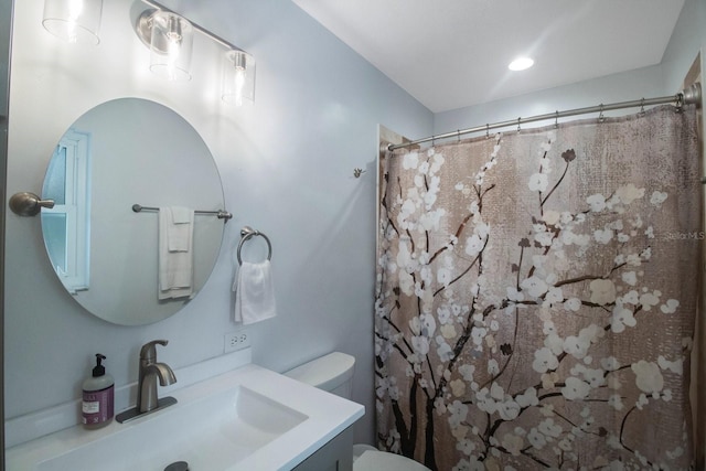 bathroom with vanity, toilet, and curtained shower