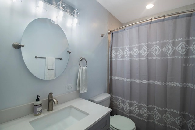 bathroom featuring vanity, toilet, and walk in shower