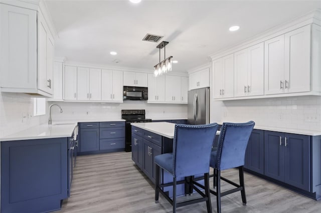 1009 Black Knight Dr, Valrico, FL 33594 - kitchen with black appliances, blue cabinetry, tasteful backsplash, light countertops, and recessed lighting