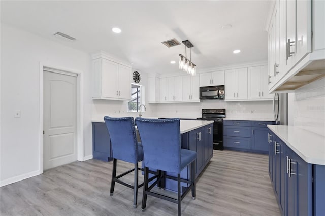 1009 Black Knight Dr, Valrico, FL 33594 - kitchen featuring black appliances, blue cabinets, a breakfast bar area, a center island, and recessed lighting