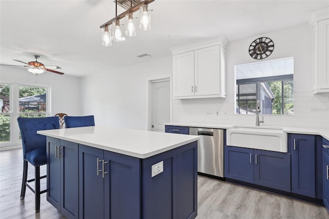 1009 Black Knight Dr, Valrico, FL 33594 - kitchen with blue cabinetry, dishwasher, a kitchen bar, and healthy amount of natural light