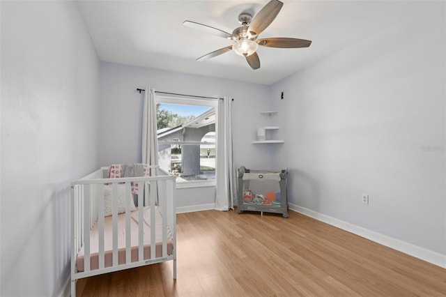 1009 Black Knight Dr, Valrico, FL 33594 - bedroom featuring light wood-style flooring, ceiling fan, and a nursery area
