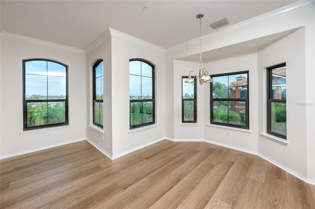 unfurnished dining area featuring crown molding, light hardwood / wood-style flooring, and an inviting chandelier