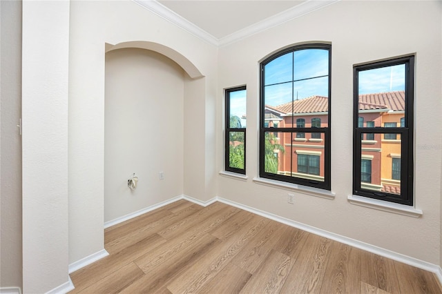 unfurnished room with light hardwood / wood-style floors and crown molding