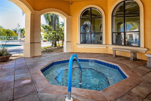 view of swimming pool featuring a hot tub