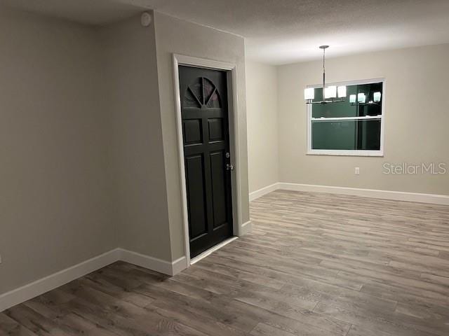 unfurnished room with hardwood / wood-style floors and a chandelier