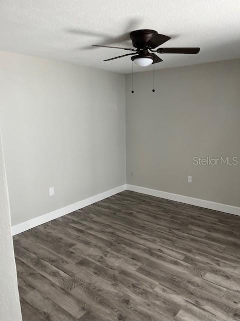 spare room featuring dark hardwood / wood-style floors, ceiling fan, and a textured ceiling