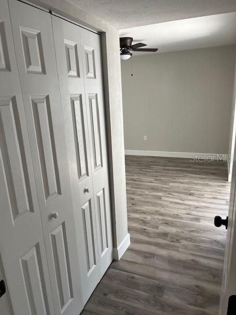 hallway with a textured ceiling and dark hardwood / wood-style floors