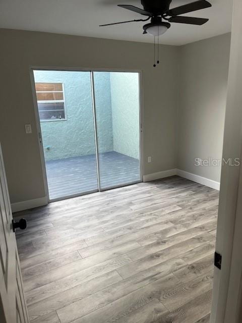 spare room featuring light hardwood / wood-style flooring, ceiling fan, and a healthy amount of sunlight