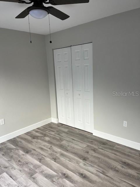 unfurnished bedroom with light wood-type flooring, a closet, and ceiling fan