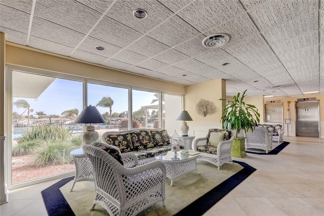 interior space featuring a drop ceiling and elevator