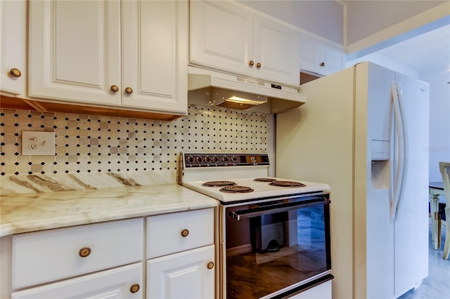 kitchen featuring white cabinets, white appliances, tasteful backsplash, and light stone counters