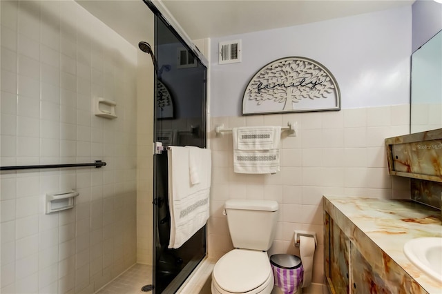 bathroom with a tile shower, vanity, and toilet