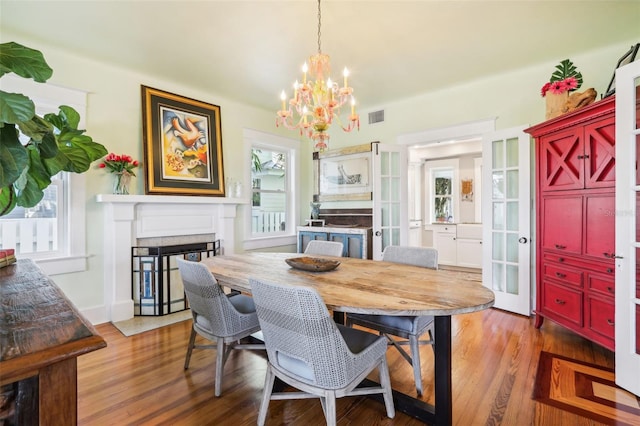 dining room with dark hardwood / wood-style flooring and a chandelier