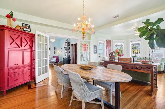 dining space with hardwood / wood-style flooring, a chandelier, and french doors