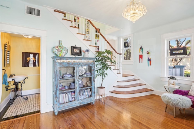 staircase featuring a notable chandelier and hardwood / wood-style flooring