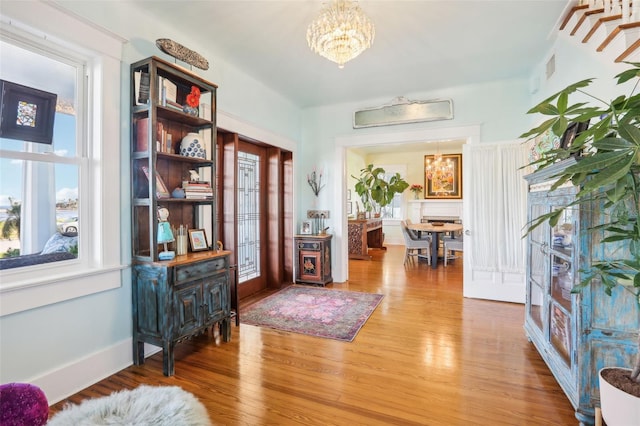 living area with hardwood / wood-style floors, plenty of natural light, and a chandelier