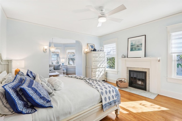 bedroom with ceiling fan, ornamental molding, and hardwood / wood-style floors