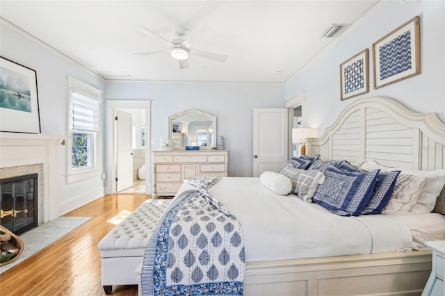 bedroom featuring crown molding, ensuite bathroom, ceiling fan, and light hardwood / wood-style floors