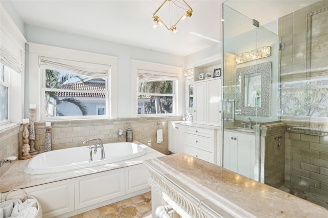 bathroom with vanity, plenty of natural light, a chandelier, and plus walk in shower