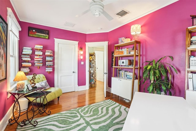 bedroom featuring crown molding, wood-type flooring, and ceiling fan