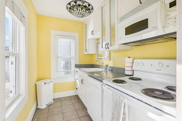 kitchen with light tile patterned flooring, white appliances, sink, and white cabinets