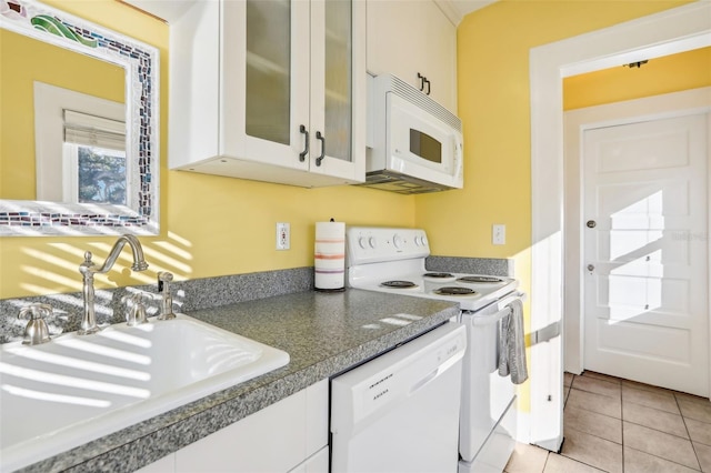 kitchen featuring sink, light tile patterned floors, white cabinets, and white appliances