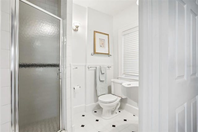 bathroom with tile patterned flooring, a shower with shower door, and toilet