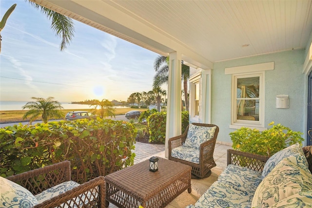 patio terrace at dusk featuring a water view