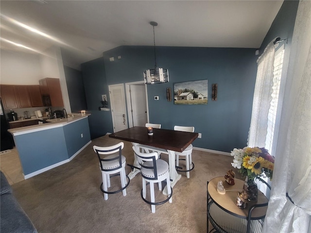 carpeted dining space with an inviting chandelier and vaulted ceiling