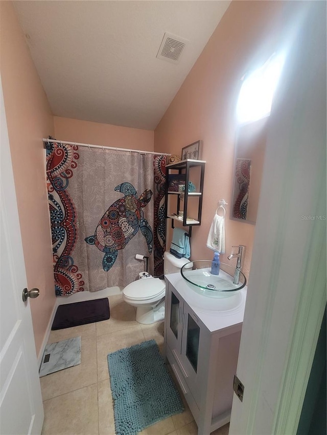 bathroom featuring tile patterned floors, vanity, toilet, and lofted ceiling