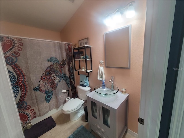 bathroom with toilet, vanity, tile patterned floors, and vaulted ceiling